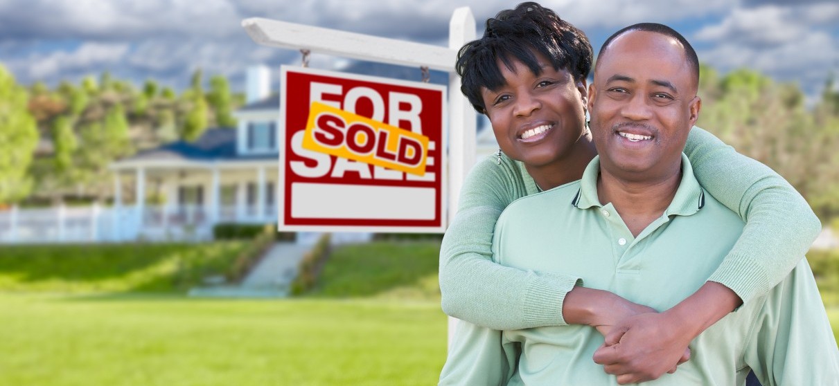 Couple in Front of Sold Sign Couple in Front of Sold Sign